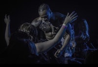 a man on stage with his hands raised in the air